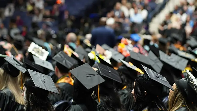 Students attending graduation in their caps and gowns