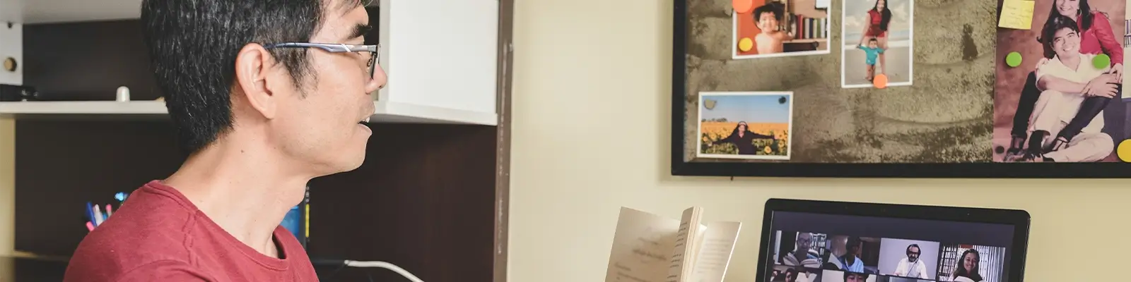 Man on a video call, reading a book with other attendees.
