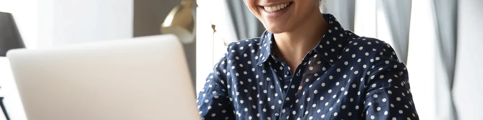 Woman using a laptop while smiling