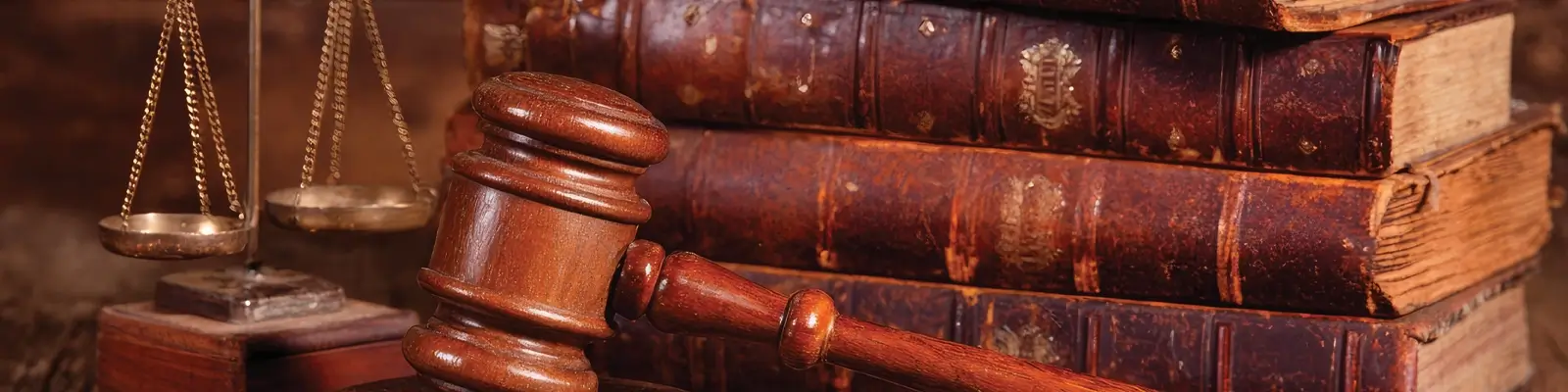 A stack of old books, a pair of scales, and a gavel