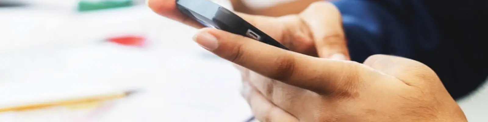 Person typing on a phone in a classroom